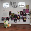Westwand: Zeichnung, Text-Bildkombination, Textposter, schwarze Bodenarbeit von Spammuseum; Emoticonbayer, gelbe Bodenarbeit und "mach dein ding..." von Chatbook